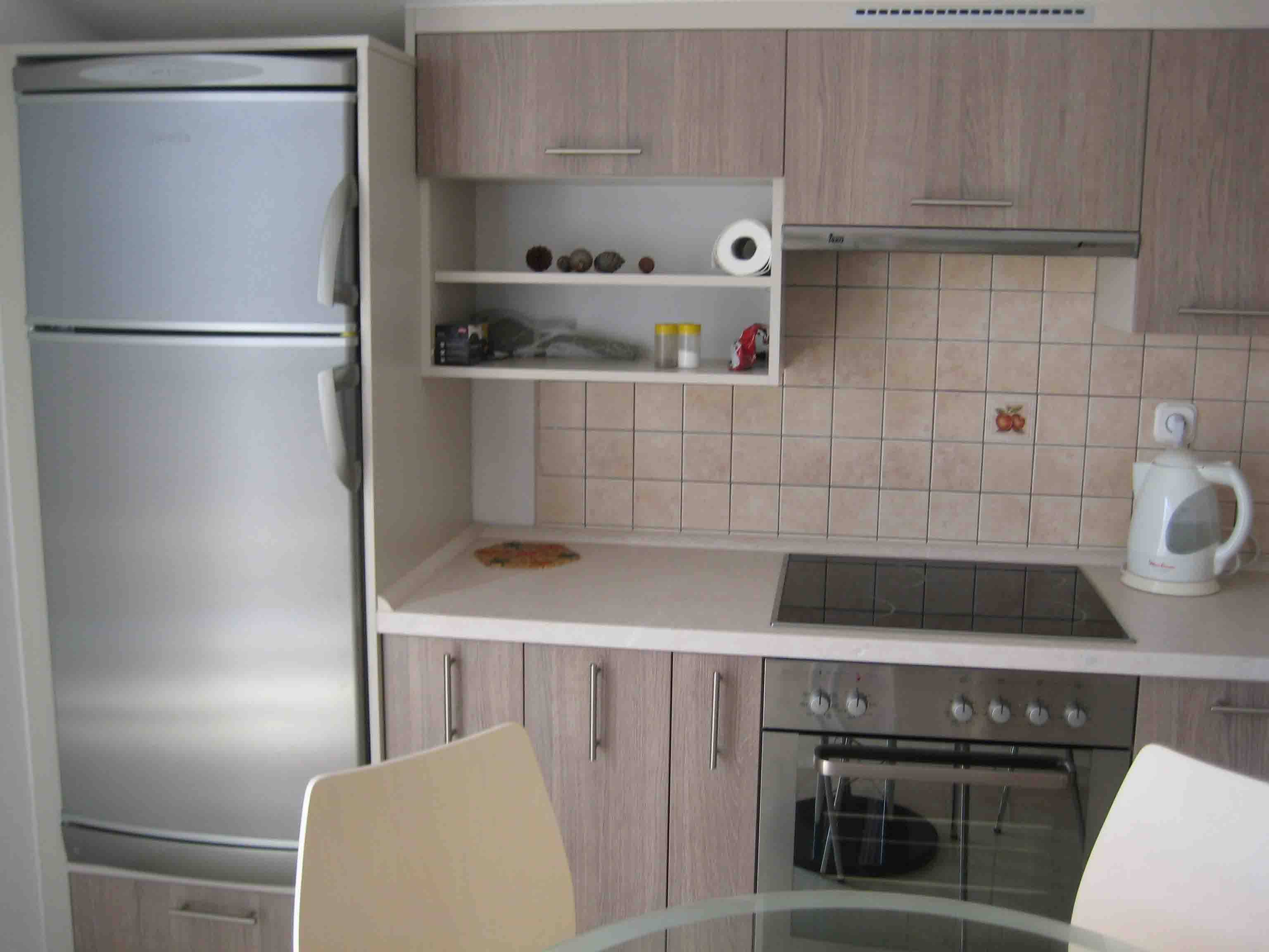 Холодильник рядом с плитой на кухне