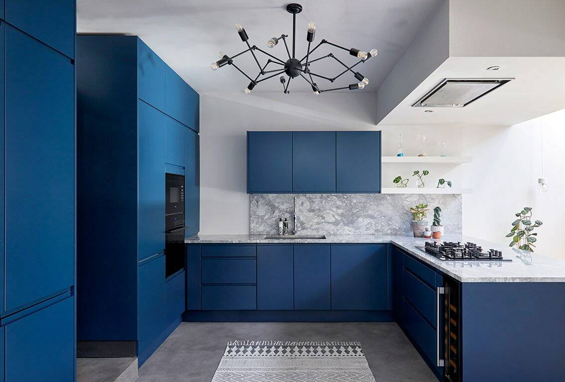 Синяя кухня в интерьере с деревянной столешницей, темным фартуком и гарнитуром
 - 37 фото